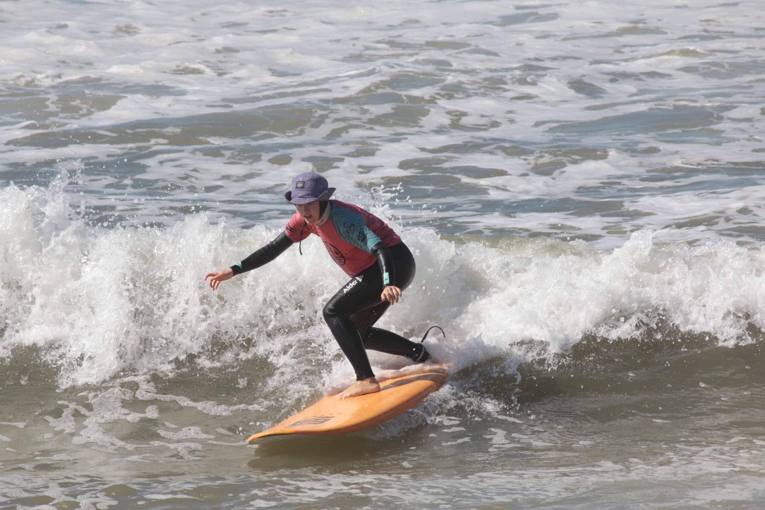 Beginner surfer catching first wave during Sea Krew surf lesson in Ericeira