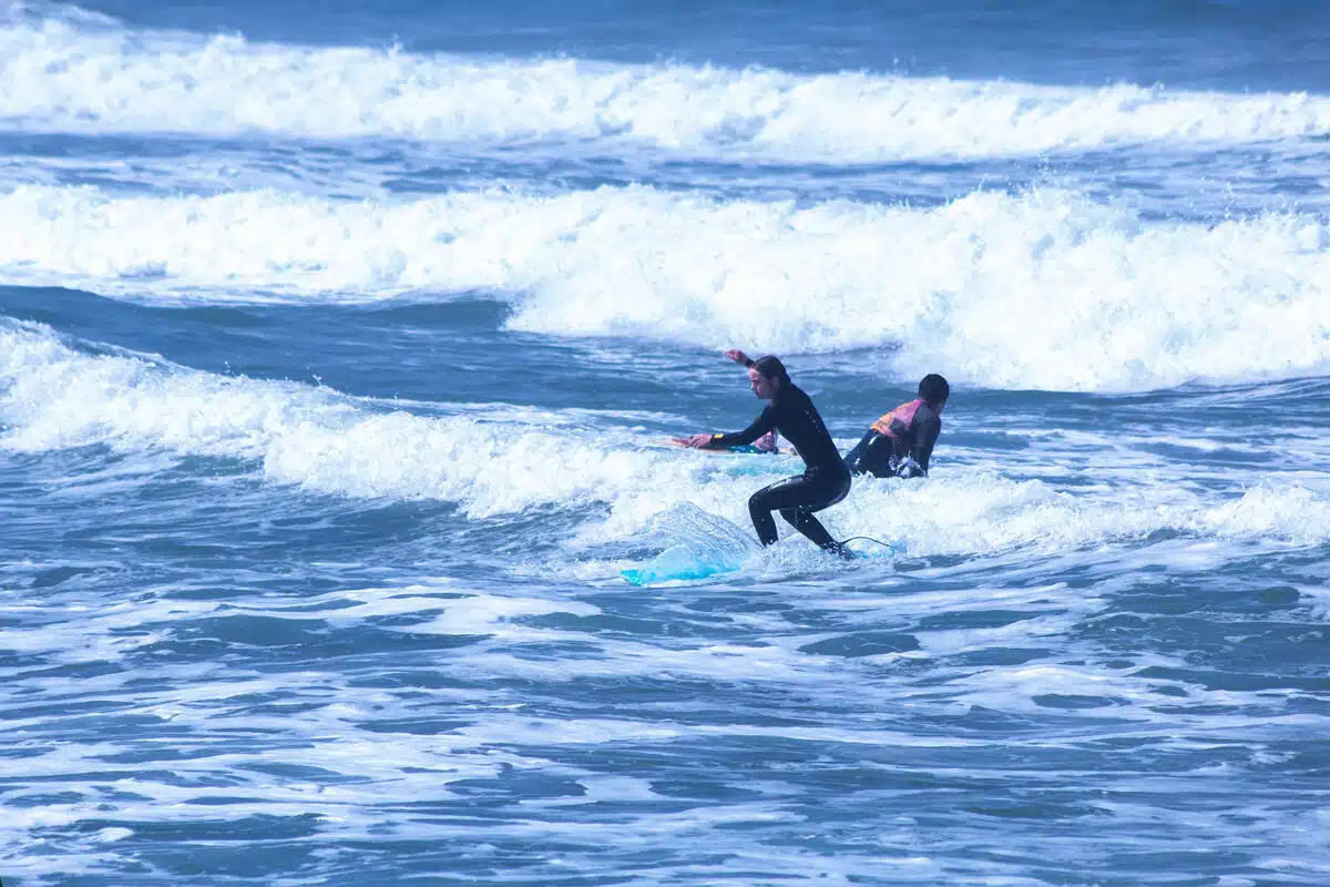 Sea Krew surf instructor assisting beginner student in Ericeira