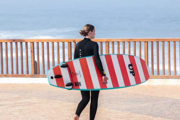 Surf lesson in Ericeira Portugal – Sea Krew beginner carrying foam surfboard
