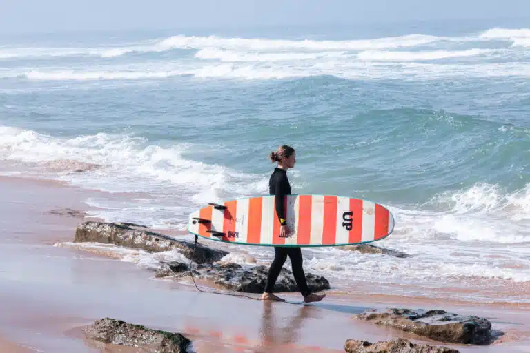 Surfer walking into the Atlantic in Ericeira – Sea Krew surf coaching Portugal
