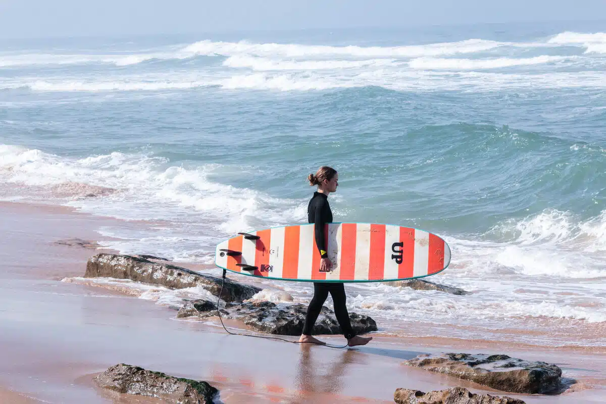 Surfer entering the ocean in Ericeira Portugal – Sea Krew surf coaching