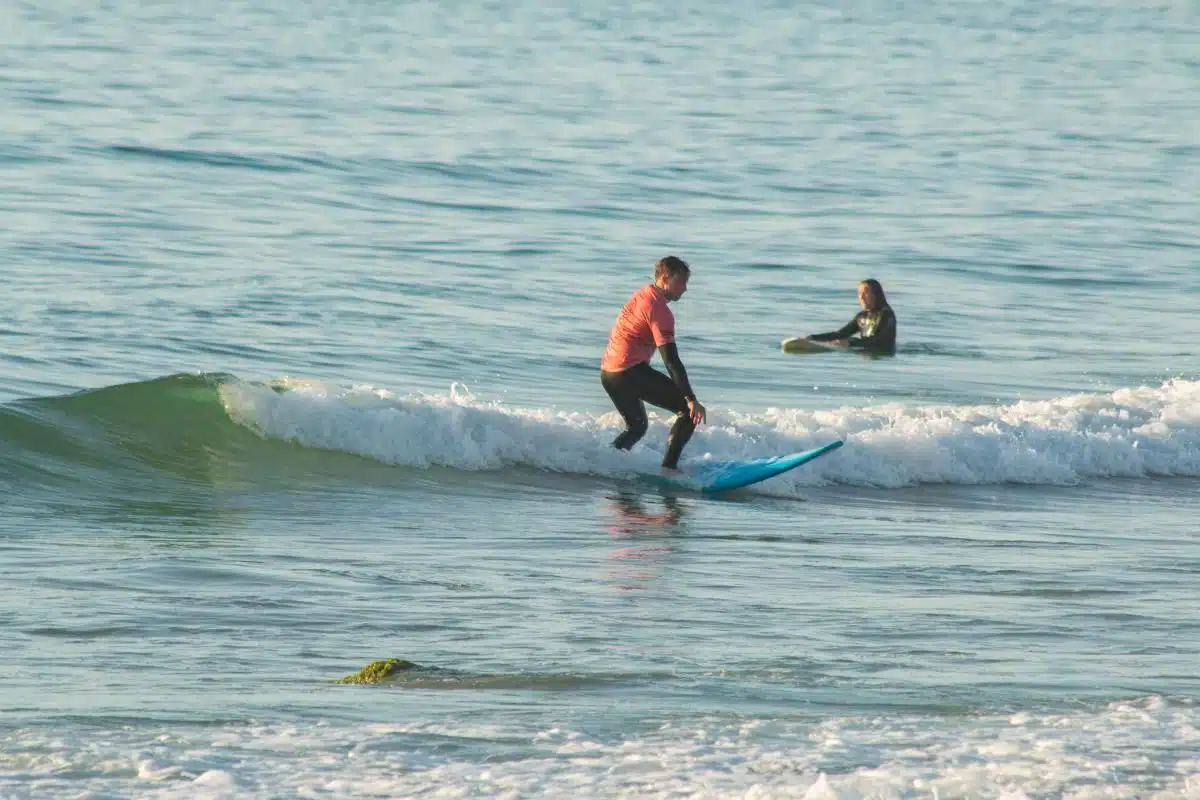 Progressing from whitewater to unbroken green waves at a surf camp