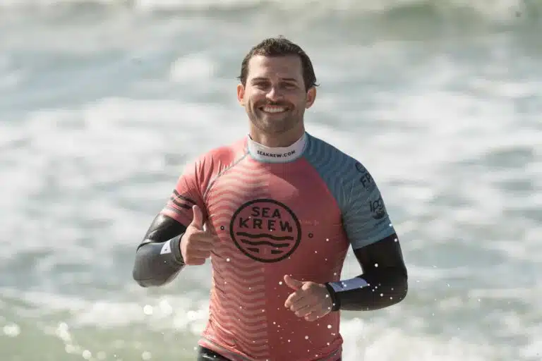Beginner surfer smiling with a thumbs up after his first surf lesson in Ericeira with Sea Krew