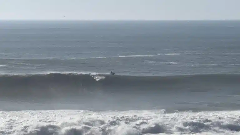 Tow surfer on a giant wave at Praia do Norte, Nazaré