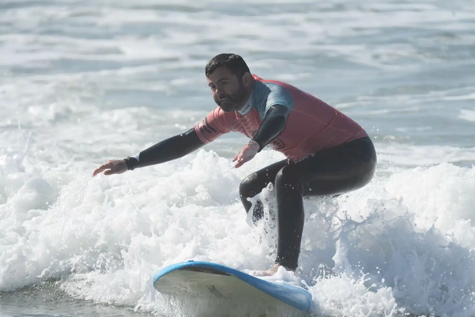 Beginner standing up on a surfboard for the first time during a surf lesson in Ericeira