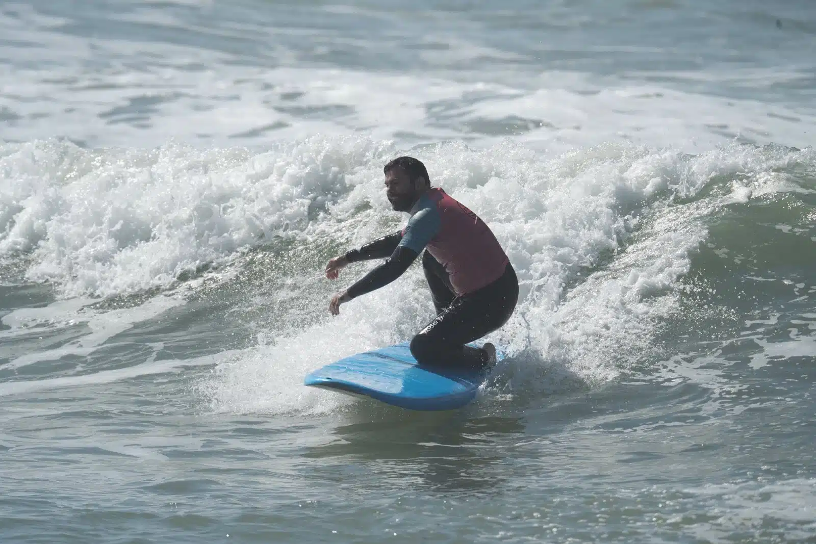 Surf club member riding a wave during a coached session in Ericeira