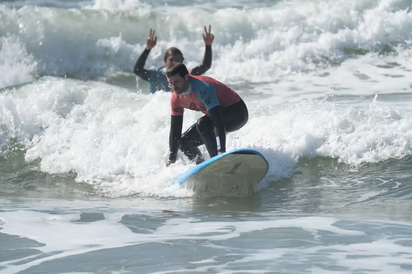 Surf club member and coach celebrating a wave in Ericeira