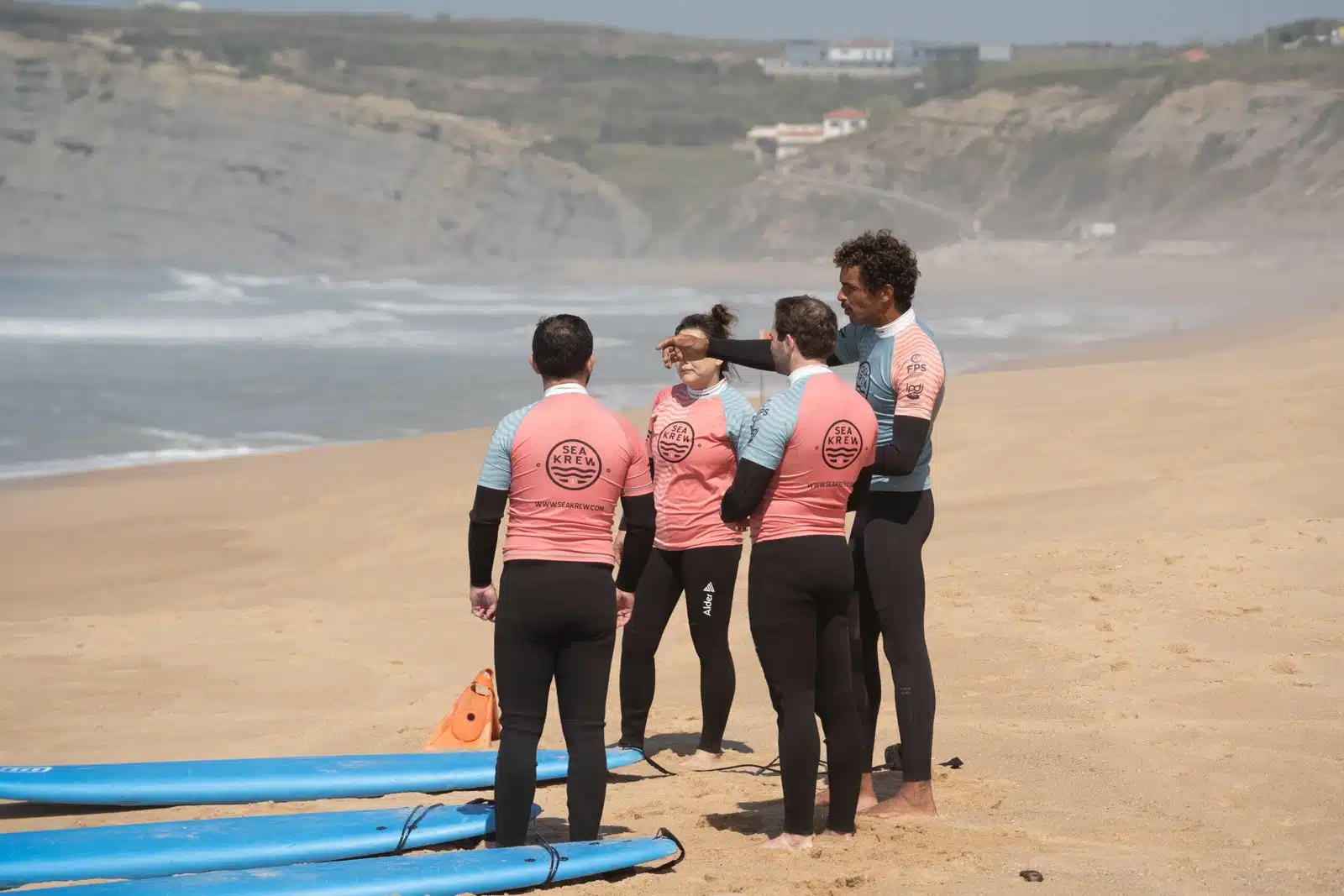 Sea Krew surf club members and coach on the beach in Ericeira before a session